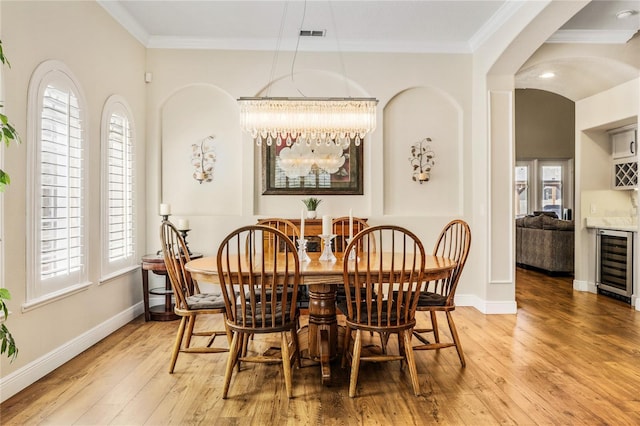 1638 Swallowtail Ln, Sanford, FL 32771 - dining space featuring crown molding, light wood-type flooring, and beverage cooler