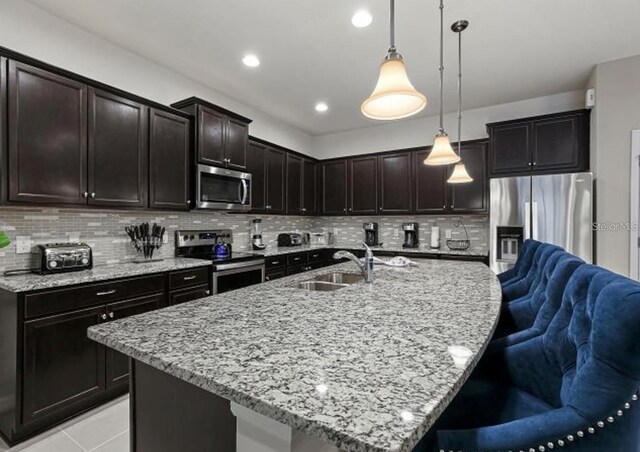 8892 Bengal Ct, Kissimmee, FL 34747 - kitchen featuring stainless steel appliances, open floor plan, backsplash, a sink, and recessed lighting