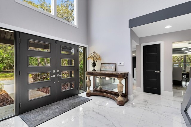 835 Dyson Dr, Winter Springs, FL 32708 - foyer entrance featuring marble tiled floors, a high ceiling, and french doors