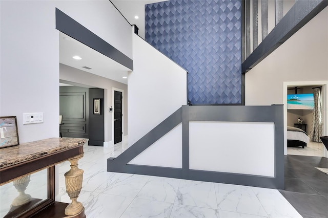 835 Dyson Dr, Winter Springs, FL 32708 - stairway featuring a high ceiling, an accent wall, marble look tiles, and recessed lighting