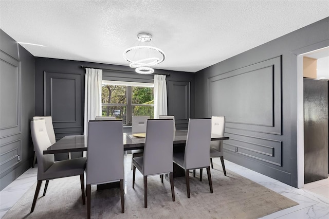 835 Dyson Dr, Winter Springs, FL 32708 - dining space featuring a chandelier, a textured ceiling, light marble finish floors, and a decorative wall