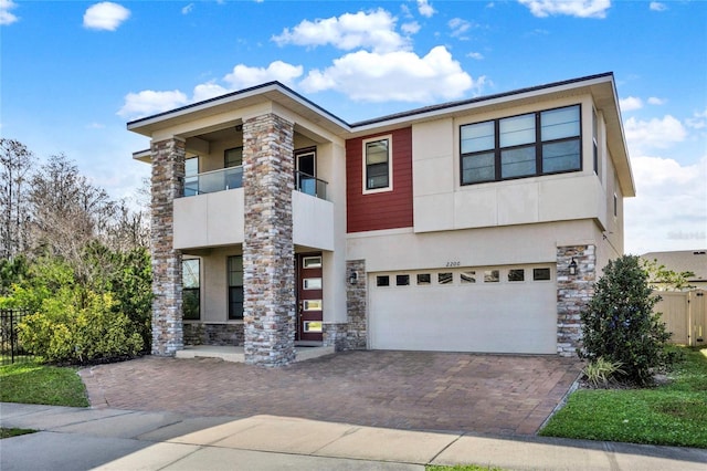 2200 Rapollo Dr, Kissimmee, FL 34741 - modern home featuring stone siding, a garage, fence, and stucco siding