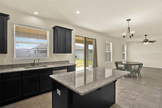 2200 Rapollo Dr, Kissimmee, FL 34741 - kitchen with a center island, dark cabinetry, a sink, and light tile patterned floors