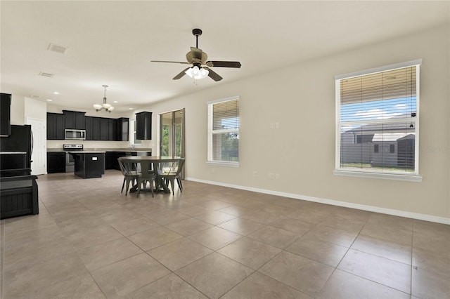 2200 Rapollo Dr, Kissimmee, FL 34741 - dining area featuring baseboards, light tile patterned floors, visible vents, and ceiling fan with notable chandelier