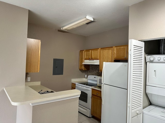9021 Lee Vista Blvd Unit 1707, Orlando, FL 32829 - kitchen featuring white appliances, under cabinet range hood, stacked washing maching and dryer, a peninsula, and electric panel