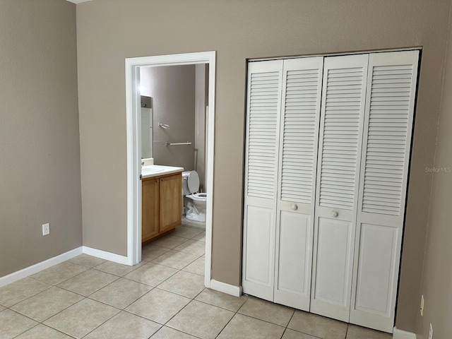 9021 Lee Vista Blvd Unit 1707, Orlando, FL 32829 - unfurnished bedroom with light tile patterned flooring, baseboards, and a closet