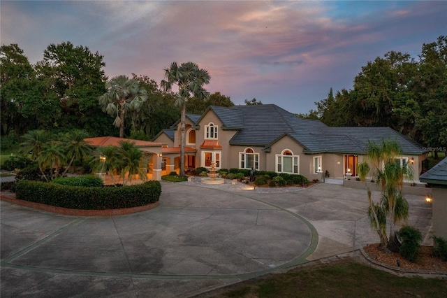 11450 Nellie Oaks Bnd, Clermont, FL 34711 - view of front of home with curved driveway, stucco siding, and french doors