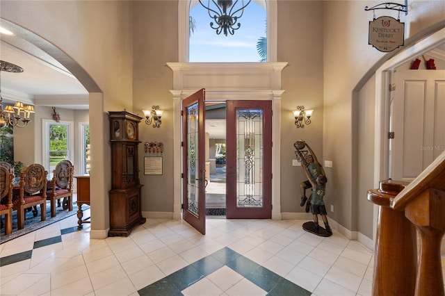 11450 Nellie Oaks Bnd, Clermont, FL 34711 - foyer entrance with a chandelier, arched walkways, light tile patterned floors, and a high ceiling