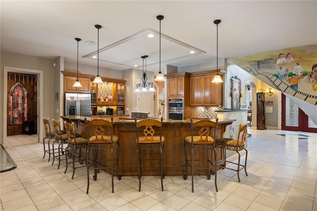 11450 Nellie Oaks Bnd, Clermont, FL 34711 - kitchen with stainless steel appliances, brown cabinetry, recessed lighting, tasteful backsplash, and glass insert cabinets