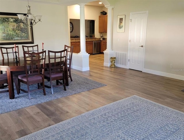 dining area with ornate columns, visible vents, baseboards, and light wood-style floors