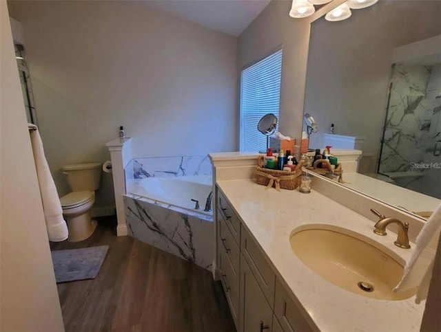 bathroom featuring a marble finish shower, toilet, wood finished floors, vanity, and a garden tub