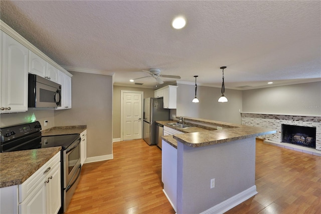 426 S Lakemont Ave, Winter Park, FL 32792 - kitchen featuring a sink, light wood finished floors, appliances with stainless steel finishes, a peninsula, and dark countertops