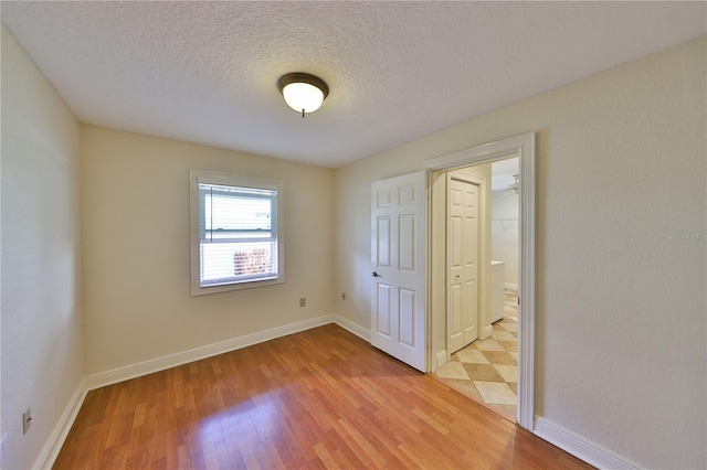 426 S Lakemont Ave, Winter Park, FL 32792 - unfurnished bedroom featuring baseboards, light wood-style floors, and a textured ceiling