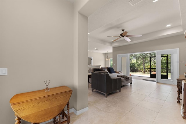 living area with recessed lighting, light tile patterned floors, a raised ceiling, a ceiling fan, and visible vents