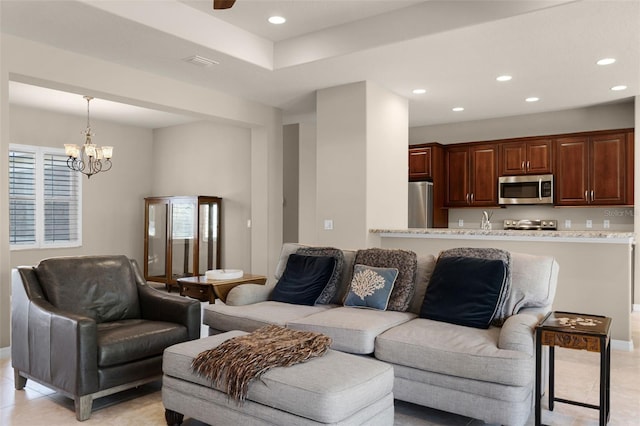 living area featuring baseboards, recessed lighting, and ceiling fan with notable chandelier