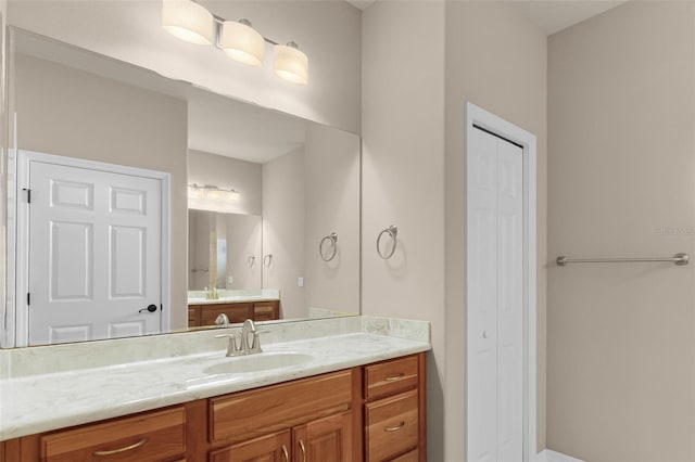 full bath with vanity and a closet