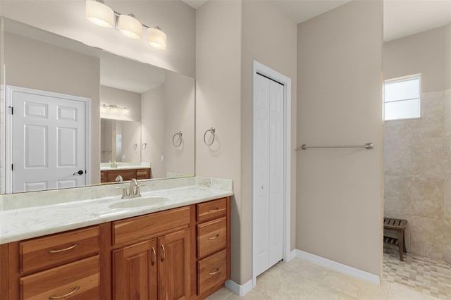 bathroom with baseboards, a closet, walk in shower, vanity, and tile patterned flooring