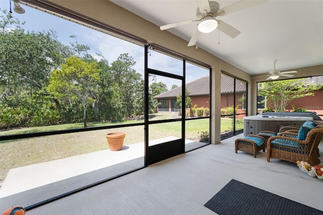 sunroom / solarium featuring a ceiling fan and a jacuzzi