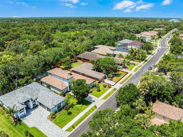 birds eye view of property featuring a wooded view and a residential view