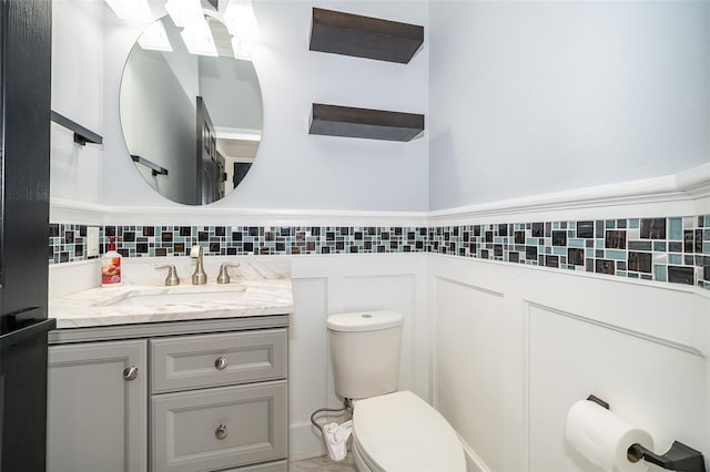 bathroom with wainscoting, toilet, and vanity