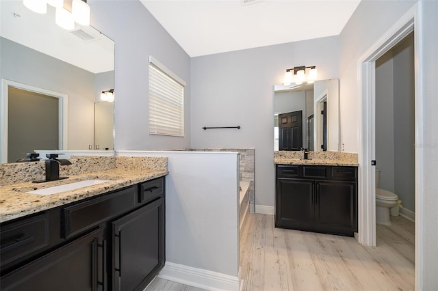 9330 Meadow Hunt Way, Winter Garden, FL 34787 - full bathroom with two vanities, wood finished floors, and a bath