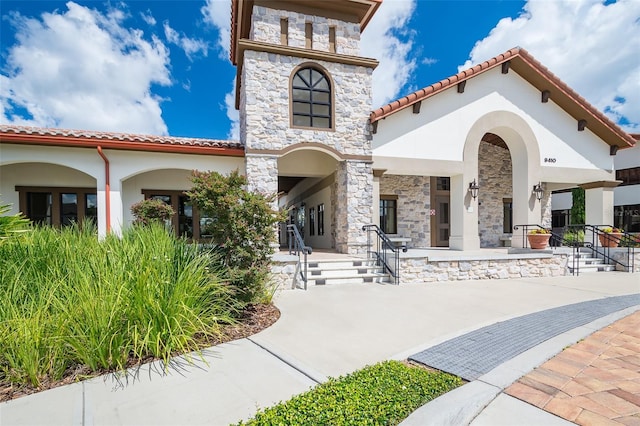 9330 Meadow Hunt Way, Winter Garden, FL 34787 - rear view of property featuring stucco siding, stone siding, and a tile roof