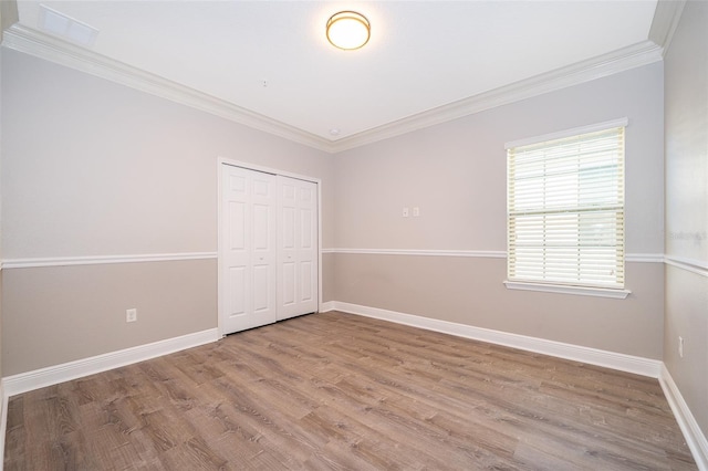 9330 Meadow Hunt Way, Winter Garden, FL 34787 - unfurnished bedroom featuring ornamental molding, a closet, and wood finished floors
