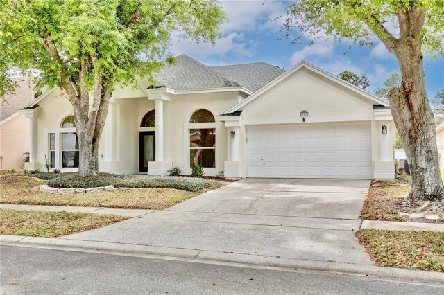 542 Terrace Cove Way, Orlando, FL 32828 - view of front of home featuring an attached garage, a shingled roof, concrete driveway, and stucco siding