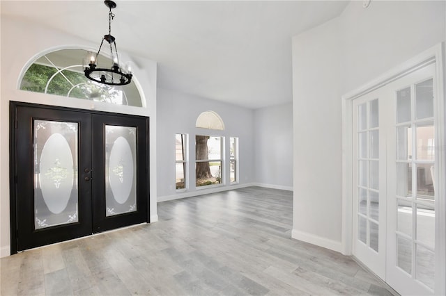 542 Terrace Cove Way, Orlando, FL 32828 - foyer entrance featuring an inviting chandelier, french doors, wood finished floors, and baseboards