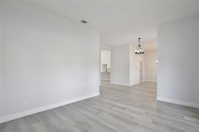542 Terrace Cove Way, Orlando, FL 32828 - empty room featuring baseboards, a chandelier, visible vents, and light wood-style flooring