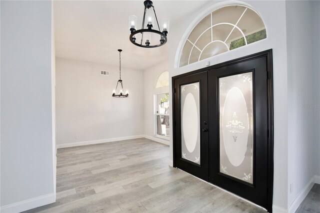 542 Terrace Cove Way, Orlando, FL 32828 - foyer featuring visible vents, baseboards, wood finished floors, and a notable chandelier