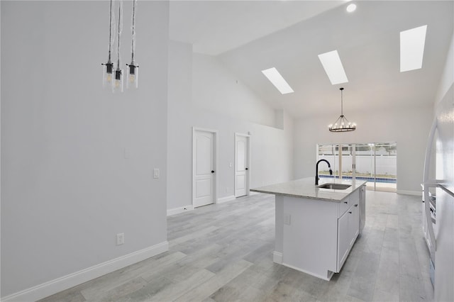 542 Terrace Cove Way, Orlando, FL 32828 - kitchen featuring high vaulted ceiling, a sink, a skylight, white cabinetry, and a notable chandelier