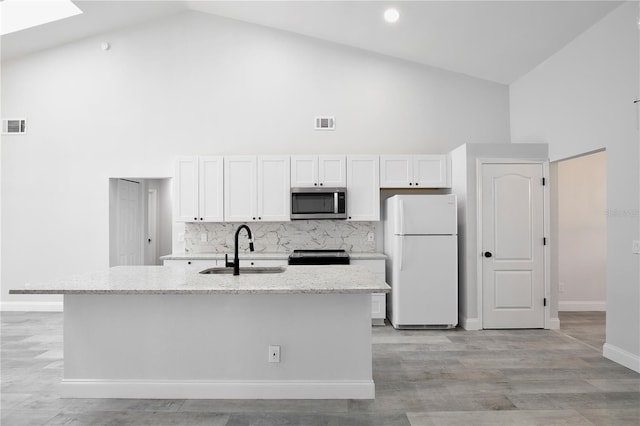 542 Terrace Cove Way, Orlando, FL 32828 - kitchen with high vaulted ceiling, appliances with stainless steel finishes, a sink, and white cabinetry