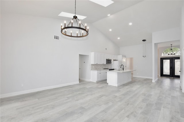 542 Terrace Cove Way, Orlando, FL 32828 - kitchen with high vaulted ceiling, open floor plan, a chandelier, white cabinets, and visible vents