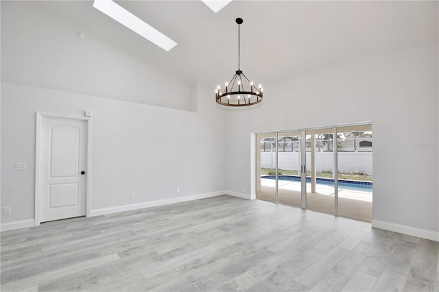 542 Terrace Cove Way, Orlando, FL 32828 - spare room with high vaulted ceiling, a skylight, an inviting chandelier, light wood finished floors, and baseboards