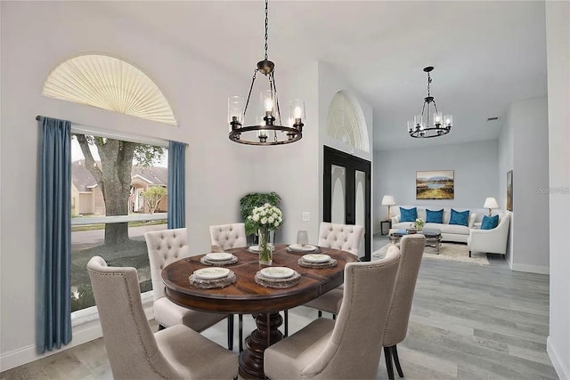 542 Terrace Cove Way, Orlando, FL 32828 - dining room with a chandelier, light wood-style flooring, and baseboards