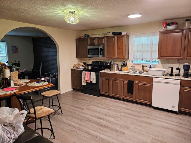 509 S Hudson St, Orlando, FL 32835 - kitchen featuring a sink, white dishwasher, stainless steel microwave, black electric range, and arched walkways