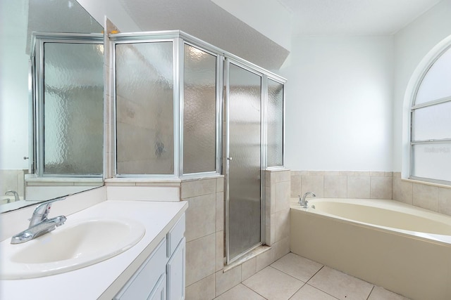 full bathroom with tile patterned flooring, a bath, a stall shower, and vanity
