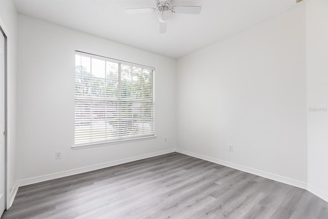 spare room with baseboards, ceiling fan, and wood finished floors