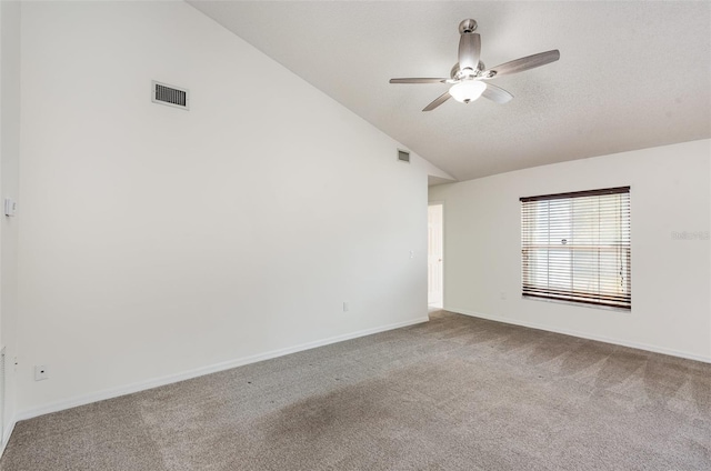 empty room featuring a ceiling fan, carpet floors, vaulted ceiling, and visible vents