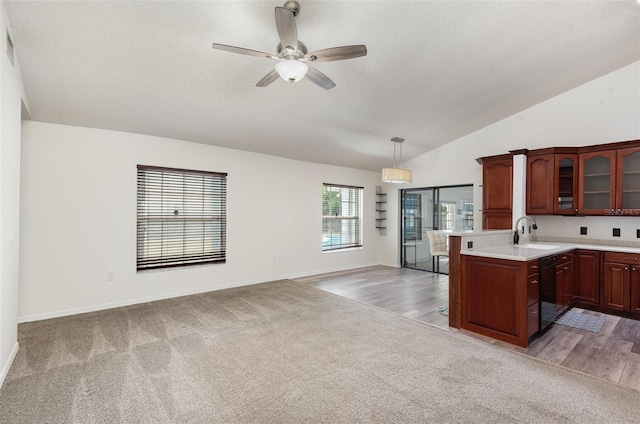 kitchen with light countertops, a peninsula, black dishwasher, glass insert cabinets, and light colored carpet