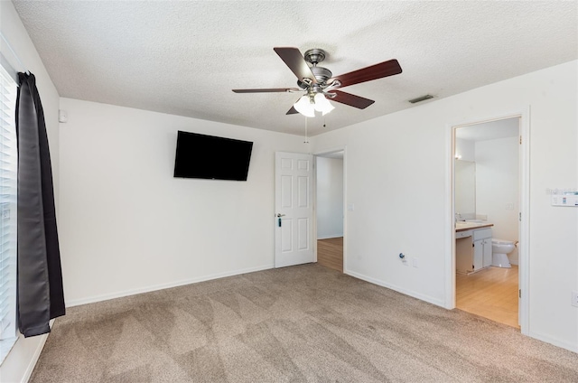 unfurnished bedroom with baseboards, a textured ceiling, visible vents, and carpet