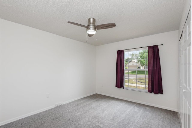 empty room featuring baseboards, carpet floors, and a ceiling fan