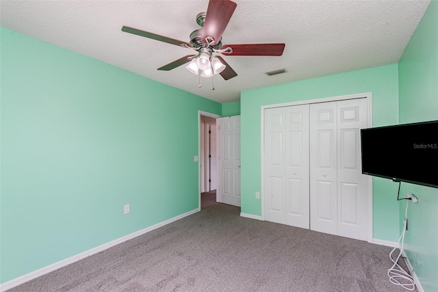 unfurnished bedroom featuring baseboards, visible vents, carpet floors, and a textured ceiling