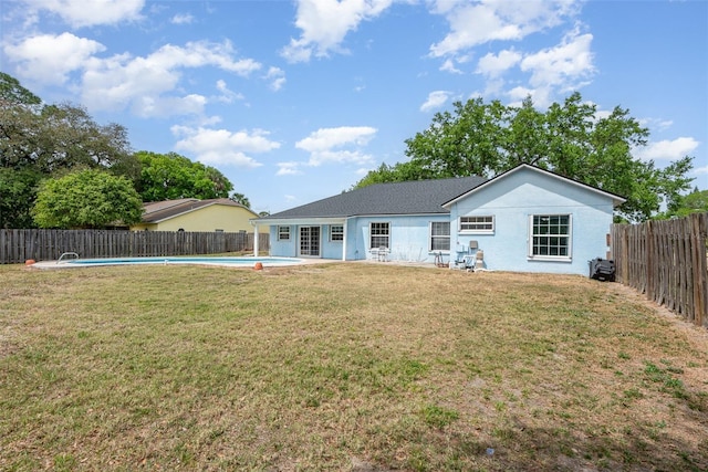 back of house with a lawn, a fenced in pool, and a fenced backyard