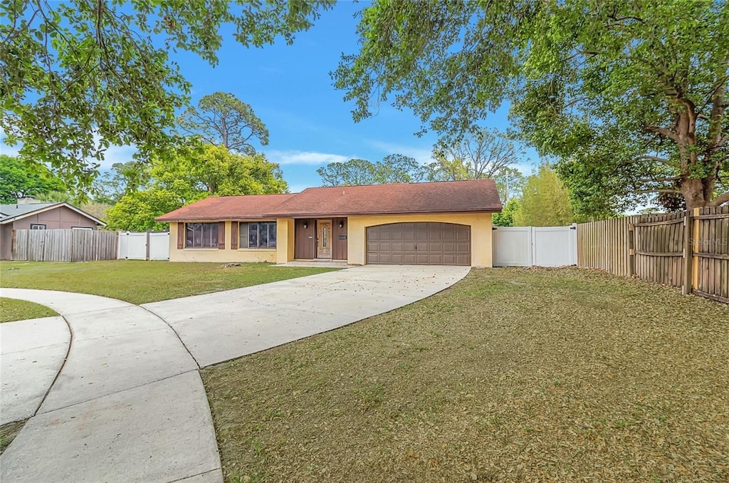 single story home with fence private yard, a front lawn, a gate, a garage, and concrete driveway