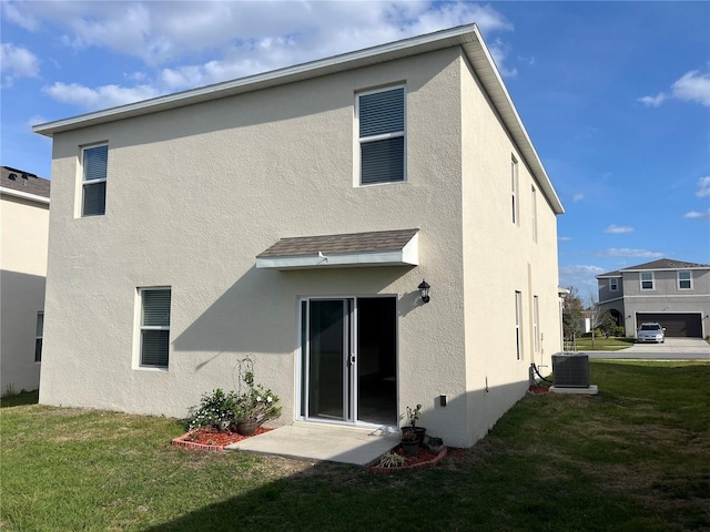 3009 Tansy St, Tavares, FL 32778 - rear view of property with central AC unit, a lawn, and stucco siding