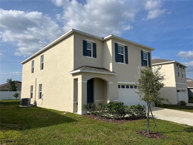 3009 Tansy St, Tavares, FL 32778 - traditional-style home featuring stucco siding, driveway, a front yard, a garage, and central AC