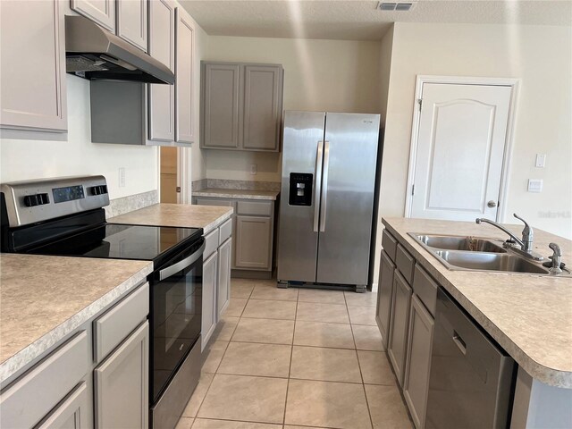 3009 Tansy St, Tavares, FL 32778 - kitchen featuring light tile patterned flooring, light countertops, a sink, appliances with stainless steel finishes, and under cabinet range hood