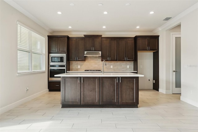 2785 Park Ridge St, Apopka, FL 32712 - kitchen with appliances with stainless steel finishes, under cabinet range hood, light countertops, decorative backsplash, and crown molding